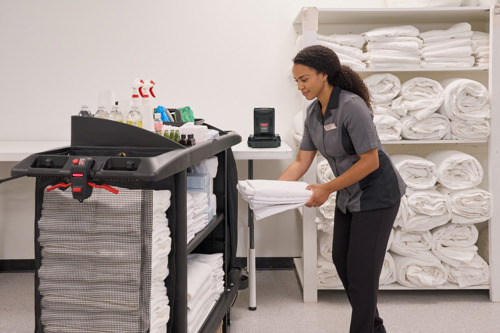 Housekeeper using housekeeping cart to store towels