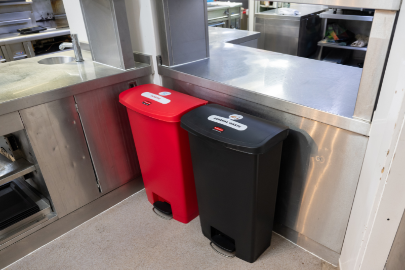 Slim Jim Step On bins with waste stream labels in a commercial kitchen