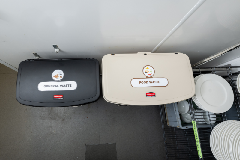 Slim Jim Step On bins with waste stream labels in a commercial kitchen
